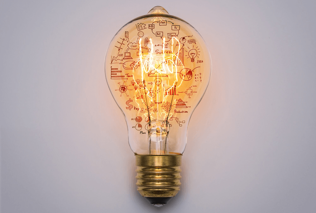 A lit lightbulb with intricate ideas and plans drawn inside, symbolizing vision and innovation.